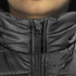 A close-up of a black puffer vest featuring a zippered collar and a logo on the zipper.