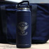 A drink bottle in navy blue with a logo and a handle, designed for hydration. Features a sleek, durable design.