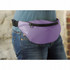 A purple hipster budget fanny pack with a zippered pocket, worn around the waist over denim jeans.