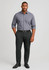 A man stands wearing a grey shirt and black stretch chino pants, complemented by a black belt and shoes.