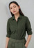 A long sleeve button-up shirt in dark green, featuring a collar and rolled sleeves, displayed on a model.