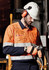A hi-vis shirt in orange with navy sleeves, featuring hoop tape, worn by a worker in protective gear.