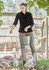 A woman wearing a black long sleeve shirt and khaki pants, engaging with chickens while holding a bucket.
