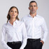 A white button-up shirt displayed on a male model and a female model, both wearing black trousers. The shirt has a logo.