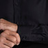 A black button-up shirt featuring long sleeves and stylish cuffs. It has a logo on the fabric.