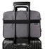 A grey laptop bag with a handle and strap, placed on top of a black suitcase. The bag has a logo.