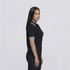 A black women's polo shirt with white stripe detailing, displayed on a female model in profile.