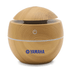 A wooden-style diffuser in a rounded design, featuring a logo and a power button on top.