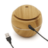 A round, wooden diffuser with a smooth, natural finish and a USB cable. It features a lid on top.