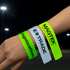 A hand featuring three reflective slap wristbands in neon green and yellow, each with different logos.