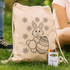 A cream drawstring bag featuring a bunny and floral design, accompanied by a crayon set in various colours.