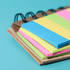A mini sticky note set featuring pastel pink, yellow, and blue notes, presented in a bamboo-style notebook.