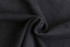 A close-up view of black 100% cotton fabric, showcasing its soft and textured surface.