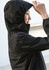 A black rain jacket with a hood, featuring a woman adjusting her hair while wearing it. The jacket has a logo.