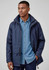 A navy unisex puffer jacket with a hood, featuring pockets and a casual fit, worn over a denim shirt.