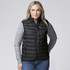 A black baffle vest is worn by a person, featuring zippered pockets and a high collar, against a plain background.