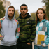 Three models wearing pullover hoodies in various styles: a light grey hoodie with floral sleeves, a green camo hoodie, and a colourful patterned hoodie.