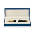 A black ballpoint pen presented in a blue and gold gift box, featuring a logo.