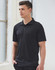 A black textured polo shirt featuring a collar and short sleeves, along with a logo on the chest.