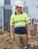 A hi-vis yellow and navy safety polo shirt featuring reflective 3M tape, worn by a male construction worker.