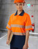 A safety polo shirt in high-visibility orange with reflective stripes and a navy blue lower section, worn by a model.