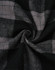 A close-up of black and grey flannel fabric featuring a plaid pattern, showcasing the texture and design.