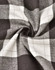 A close-up of grey and white flannel fabric with a plaid pattern, showing the texture and weave.