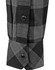 A black and grey checkered flannel shirt featuring a buttoned cuff and a logo.