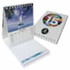 A compact, multi-coloured desk calendar with a ring binding and an image of a sailboat. It includes a notepad section.