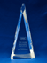 A large, clear crystal triangular award with a branding logo, resting on a blue background.
