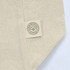 A cream-coloured tote bag made from 100% recycled cotton, featuring a tag with a logo.
