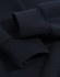 A close-up of a navy polar fleece jumper featuring half zip collar and ribbed cuffs with an unobtrusive logo.