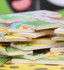 A stack of colourful wooden jigsaw puzzle pieces featuring various designs and characters.