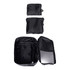 Three black packing cubes of varying sizes, with one open to reveal internal compartments, displaying a zippered design.