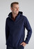 A man wearing a navy rain jacket with a hood, featuring a zipper and side pockets, and a logo on the sleeve.