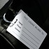 A large black luggage tag featuring a white identification label for name, phone, and address.