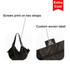 A foldable shopping shoulder bag in black, featuring screen print on two straps and a custom woven label.