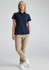 A woman in a navy short sleeve polo shirt paired with khaki trousers and white sneakers. The shirt has a logo.