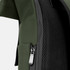 A close-up of a green soft-touch flap backpack, featuring a zipper and mesh side panel.