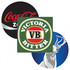Three round coasters featuring designs: one green with 'Victoria Bitter', one black with a logo, and one blue with a deer.
