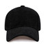 A black corduroy baseball cap with a rounded crown and a curved peak, featuring a logo on the front.