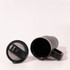A double wall mug in black with a detachable lid, featuring a handle and a sleek design.