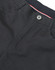 A close-up of black ladies' flexi chino pants, featuring a button and zip fly, with a hint of red and white detailing.
