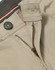 A close-up of beige chino pants featuring a zipper, button, and waistband details. The fabric has a textured finish.