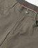 A close-up view of the waistband and button of khaki flexi chino pants featuring a logo.