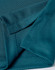 A close-up of a teal fabric featuring a jacquard knit pattern, showing the texture and stitching details.