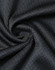 A close-up of black jacquard knit fabric, displaying a textured swirl pattern with a smooth finish.