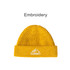 A round, yellow beanie with a ribbed design and a logo featuring mountains and text on the cuff.