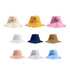A collection of Raw Edge Bucket Hats in various colours, including pink, yellow, white, navy, and brown, featuring some logos.