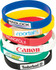A stack of silicone wristbands in various colours, featuring different logos and branding on each band.